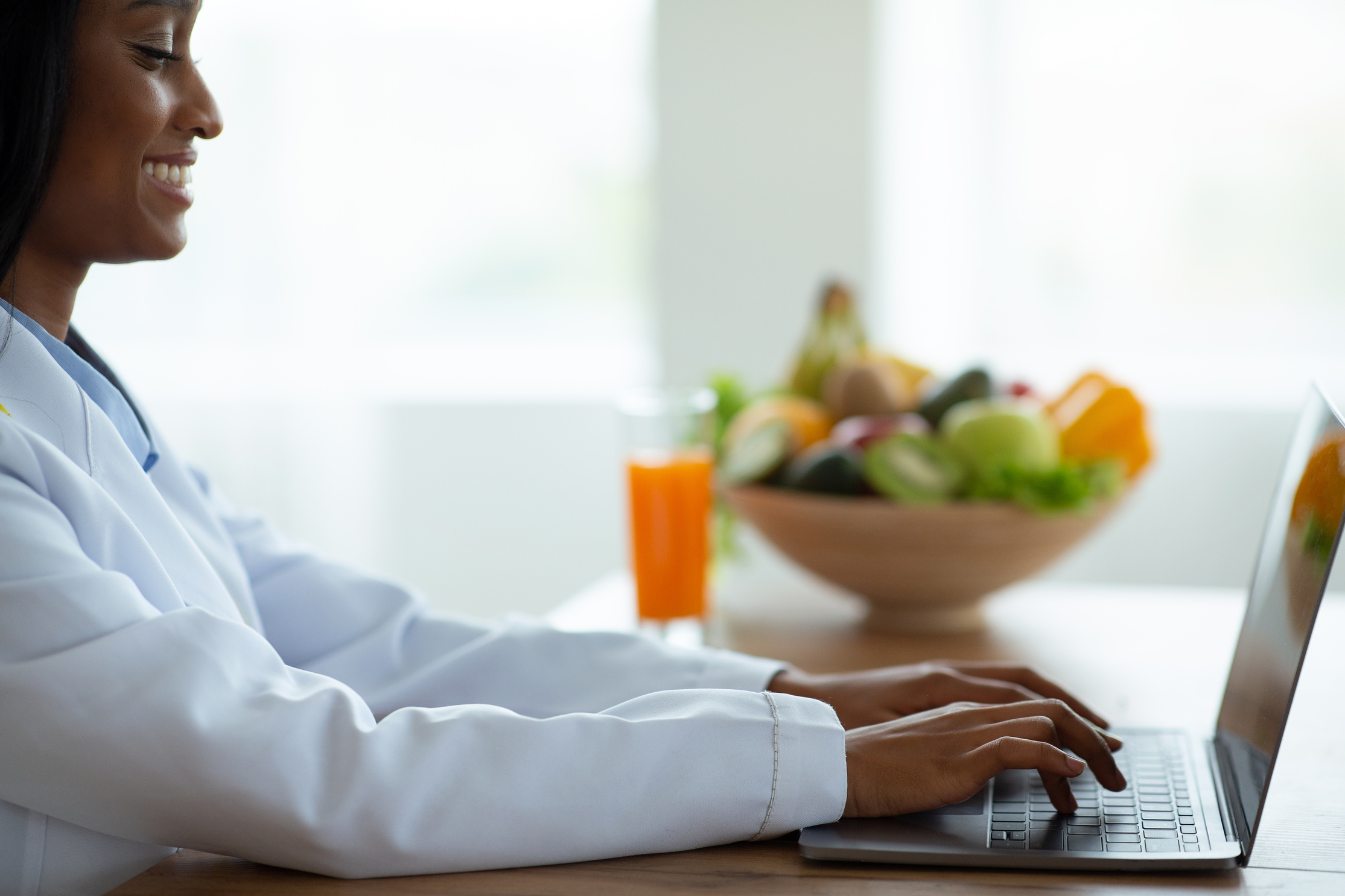 Healthy nutrition. Weight loss consultant typing on laptop computer, giving online consultation to patient at clinic